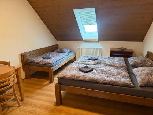 a bedroom with two beds and a table and a window at Rašovka - Bílý dům in Šimonovice