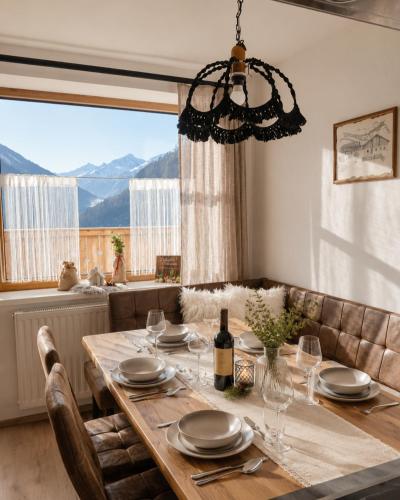 a dining room table with a bottle of wine at Boutique Appartements Kumming inkl Nationalparkcard in Rauris