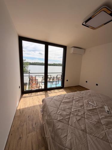 a bedroom with a large bed and a large window at No Stress in Borča