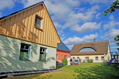a house with a gambrel roof and a barn at Ferienappartements zum Ostseestrand mit Terrasse in Lobbe