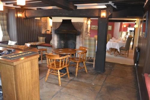 Wass的住宿－The Stapylton Arms，一间带桌子和壁炉的用餐室