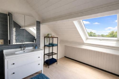 ein Badezimmer mit Waschbecken und Fenster in der Unterkunft Villa Intensity in Bastogne