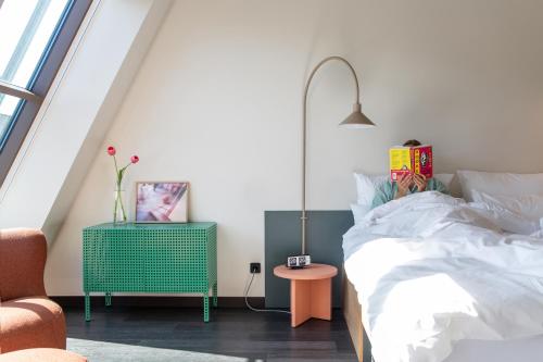 a bedroom with a bed and a table with a lamp at STAYERY Fürth City Center - alle Zimmer mit Klimaanlage in Fürth