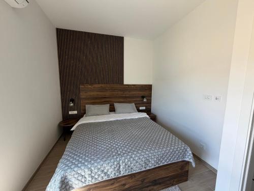 a bedroom with a bed with a wooden headboard at Zenith Lux Apartment Beachfront & Parking in Bijela