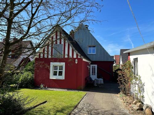 a red house with a white window on the side of it at "Ferienhaus Großenaspe" in Großenaspe