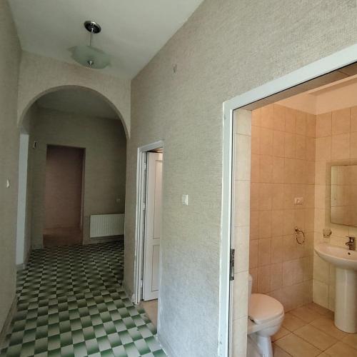 an empty bathroom with a toilet and a sink at Riviera Guesthouse in Dilijan