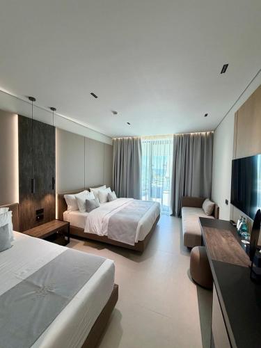 a large hotel room with two beds and a couch at Padma Hotel in Vlorë