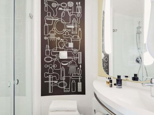 a bathroom with a black and white pattern on the wall at ibis Bordeaux Centre Bastide in Bordeaux