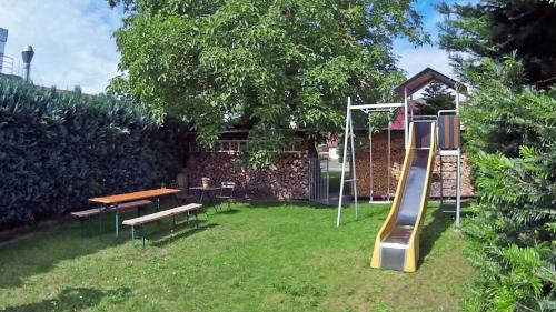 a playground with a table and a slide in a yard at Ferienwohnung Sperlingslust in Niepars