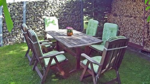 a wooden table with four chairs and a wooden table and chairs at Ferienwohnung Sperlingslust in Niepars