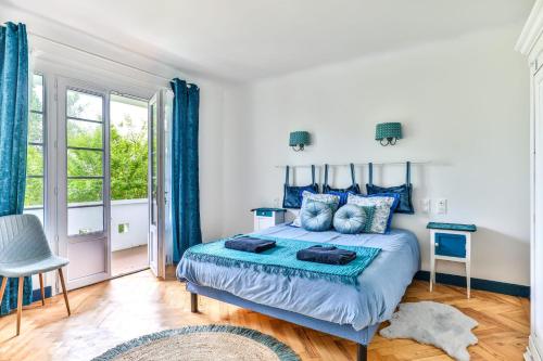 a bedroom with a blue bed and a window at Maroutine - AC - Piscine & Tennis in Labouheyre