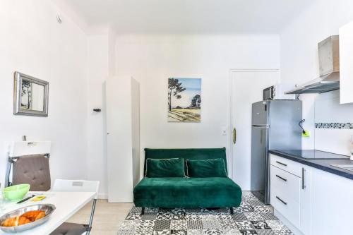a kitchen with a green chair in a white kitchen at Lavignottes - AC - Piscine & Tennis in Labouheyre