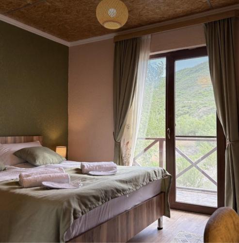 ein Schlafzimmer mit einem Bett und einem großen Fenster in der Unterkunft Iora Winery in Sagarejo
