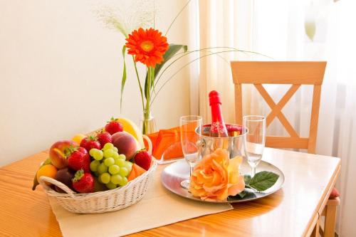 a table with a basket of fruit and wine glasses at Gästehaus Nöchel in Reinhardshausen