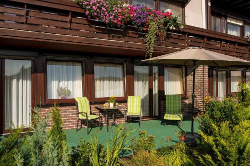 a patio with a table and chairs and an umbrella at Gästehaus Nöchel in Reinhardshausen