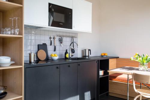 a kitchen with a black cabinet and a counter top at STAYERY Fürth City Center - alle Zimmer mit Klimaanlage in Fürth