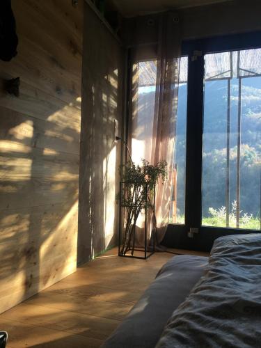 a bedroom with a bed in a room with large windows at Il wokini in Castel Vittorio