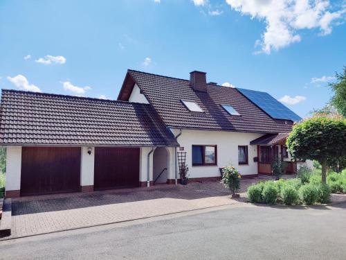 a white house with a black roof at Ferienwohnung Edersonne in Hemfurth-Edersee