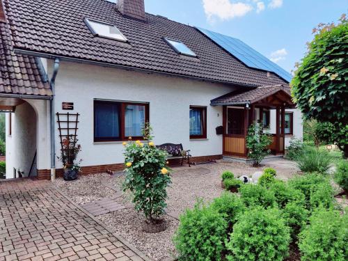a white house with a patio and some bushes at Ferienwohnung Edersonne in Hemfurth-Edersee