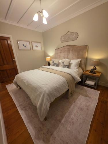 a bedroom with a large bed with a large headboard at Kingfisher Lodge Waterfront Retreat in Tairua