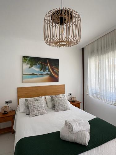 a bedroom with a bed and a chandelier at El paraíso I in Raxó