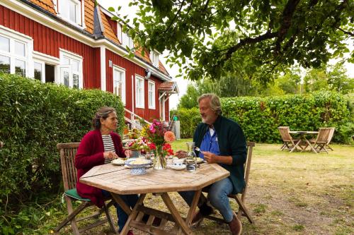 a man and woman sitting at a wooden table at Blankaholms Gästgiveri in Blankaholm