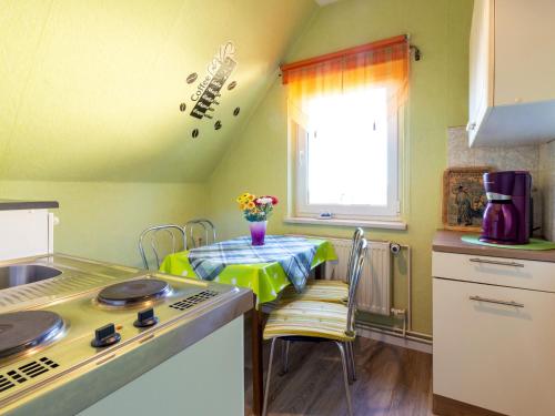 a kitchen with a table and a stove and a window at Ferienwohnung Familie Schmidt in Bergen auf Rügen