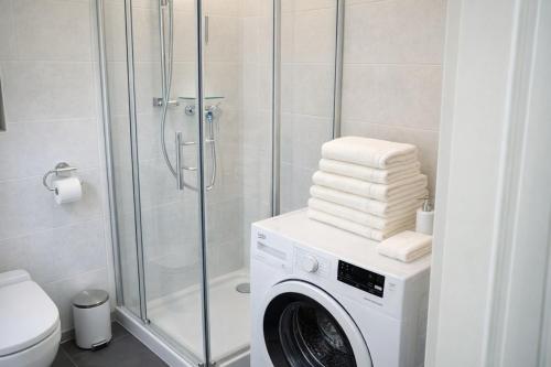 a bathroom with a washing machine and a shower at APSTAY Bungalow I Parking option & Self Check-in in Graz