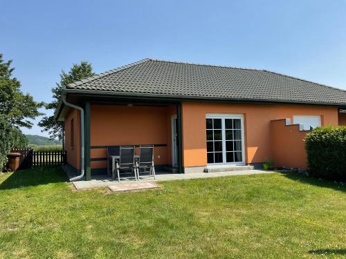 a small house with two chairs in a yard at Rügen Fewo 211 in Parchtitz