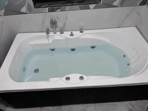 a white bath tub with a faucet in a bathroom at HOTEL ROSE PRIMe in Anand