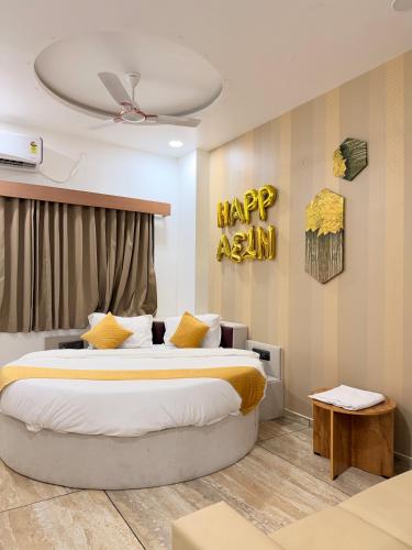 a bedroom with a bed with a happy asian sign on the wall at HOTEL ROSE PRIMe in Anand