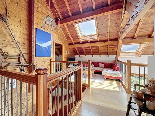 a log home with a staircase and a living room at Chalet Face aux Etoiles in Molines-en-Queyras