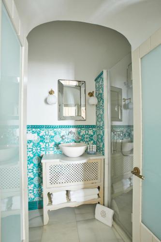 a bathroom with a sink and a mirror at Posada La Sacristía Tarifa in Tarifa