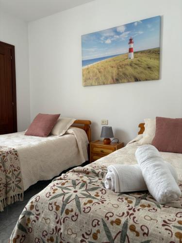 a room with two beds and a lighthouse on the wall at El paraíso in Raxó
