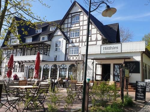 a building with tables and chairs in front of it at Hotel Hiddensee Hitthim in Kloster