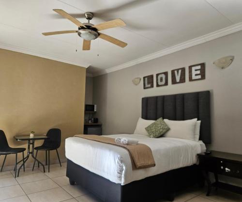 a bedroom with a bed and a ceiling fan at Oblique Boutique House in Centurion