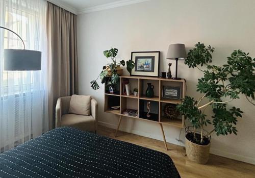 a bedroom with a bed and a shelf with plants at Apartament 101 in Piła