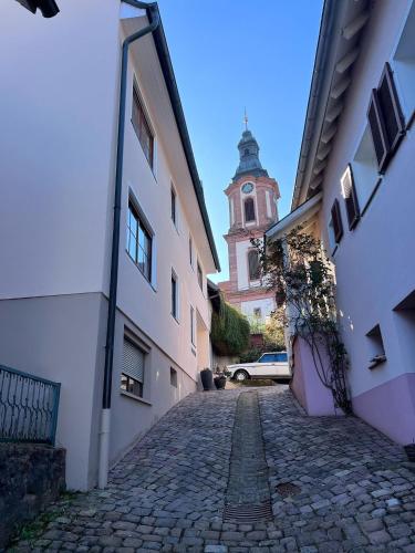 a cobblestone street with a building with a clock tower at Ferienwohnung Furtwängler in Ettenheim