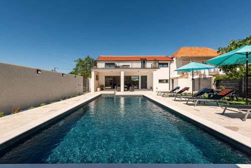 a swimming pool in the backyard of a house at Villa Flora Zadar Villas in Perušić Benkovački