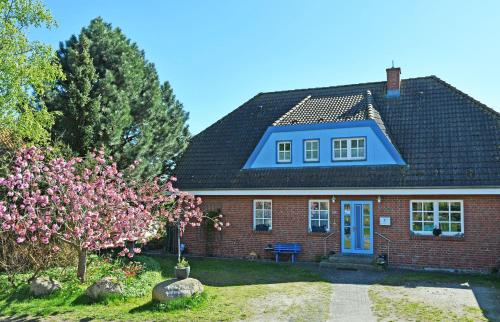 a red brick house with a blue roof at Ferienwohnung an den Vilmnitzer Wi in Vilmnitz