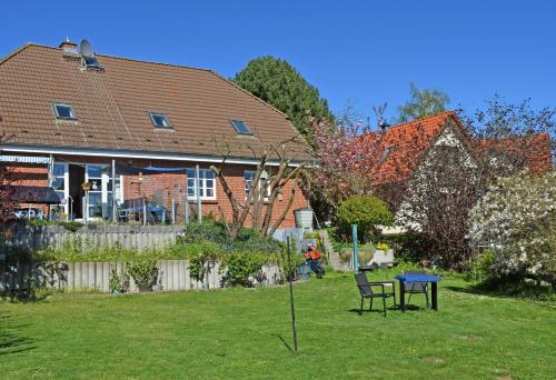 a house with a table and chairs in a yard at Ferienwohnung an den Vilmnitzer Wi in Vilmnitz
