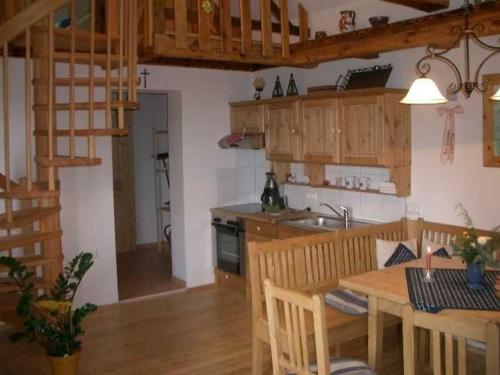 a kitchen with a table and a kitchen with wooden cabinets at Kellerstöckl Leitner in Strem
