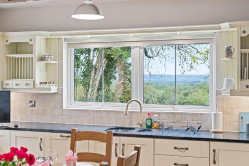 a kitchen with a large window and a sink at Hilltop Views by Escape Ordinary in Killyhevlin