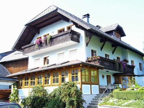 ein großes weißes Gebäude mit Balkonen und Blumen darauf in der Unterkunft Minabauer in Altmünster