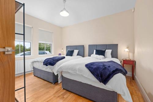 a bedroom with two beds and a large window at Hilltop Views by Escape Ordinary in Killyhevlin