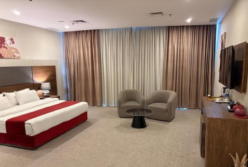 a hotel room with a bed and a television at Garden Hotel in Kuwait