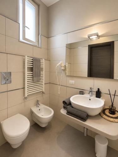 a white bathroom with a toilet and a sink at Dimora del tramonto in Trani