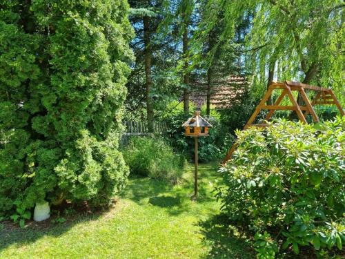 a garden with a bird feeder in the grass at Haus "Belvidere" in Elend