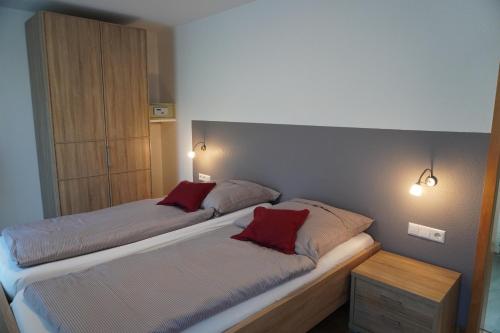 a bedroom with two beds with red pillows at Feriengut Bohn in Bernkastel-Kues