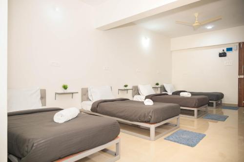 a room with three beds and a ceiling at Z Express Zen Elite in Pune